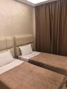 a bedroom with two beds and a curtain at Nour sakane in Oulad Akkou +5 photos