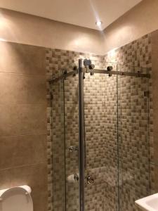 a shower with a glass door in a bathroom at Nour sakane in Oulad Akkou