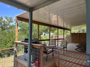 a screened in porch with two chairs and a desk at Blessed Bull at the Creek in Bandera