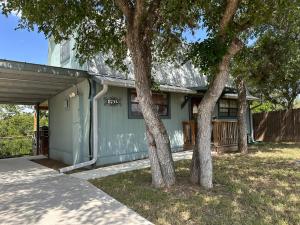 ein grünes Haus mit zwei Bäumen davor in der Unterkunft Blessed Bull at the Creek in Bandera