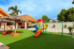 a playground with a slide on a lawn at The Orange House Pool Villa Pattaya in Jomtien Beach