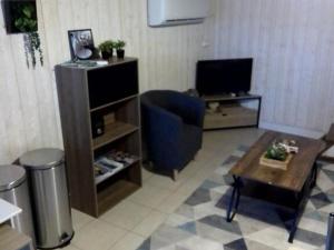 sala de estar con TV y silla azul en Maison de charme à Cros - 3 pers, Parc des Volcans - FR-1-814-133, en Cros