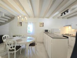 a kitchen with a white table and chairs in a room at Charmante maison près de Bergerac avec jardin privatif - FR-1-616-482 in Ginestet