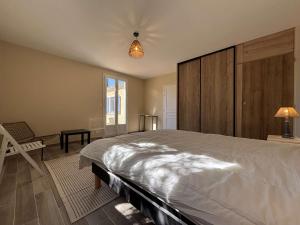 a bedroom with a large bed and a chair at Maison rénovée 6 pièces, 10 couchages à 300m de la plage, Saint-Georges-d'Oléron - FR-1-246A-357 in Saint-Georges-dʼOléron