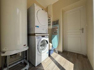 a laundry room with a washer and dryer next to a door at Maison rénovée 6 pièces, 10 couchages à 300m de la plage, Saint-Georges-d'Oléron - FR-1-246A-357 in Saint-Georges-dʼOléron