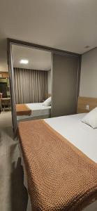 a bedroom with two beds and a large mirror at Um lugar de charme e aconchego - Gérbera! in Brasilia