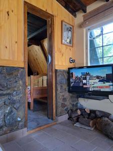 a living room with a flat screen tv on a wall at Anto'n casa de montaña in Potrerillos +32 photos