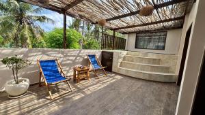 due sedie blu e un tavolo su un patio di Cantika Villa a Gili Trawangan