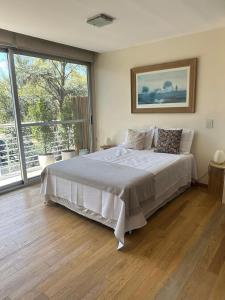 a bedroom with a large bed and a large window at Espectacular Departamento en Concord Pilar con cochera in La Lonja