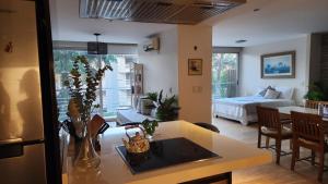 a kitchen and living room with a table and a bed at Espectacular Departamento en Concord Pilar con cochera in La Lonja