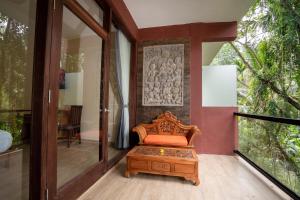 a room with a bench on a balcony at Umah Temuku Ubud in Ubud