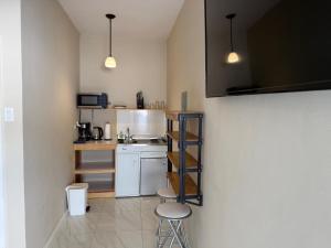 a small kitchen with two stools and a counter at Finn Room - Ferdie's Place in Port Antonio