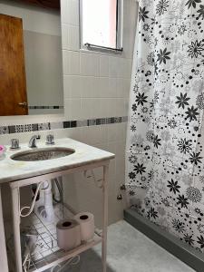 un bagno con lavandino e tenda da doccia di La Floridita a Puerto Pirámides Altre 32 foto