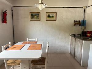 una cucina con tavolo e tavolo e sedie bianchi di La Floridita a Puerto Pirámides