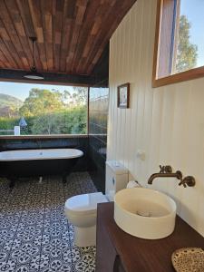a bathroom with a tub and a toilet and a sink at Homeo Alpine Cottage in Omeo +27 photos