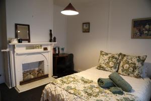 a bedroom with a bed with a fireplace at Homeo Alpine Cottage in Omeo