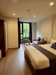 una camera d'albergo con un letto e un soggiorno di The Base Central Phuket-B42WL a Ban Rangeng