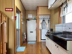 a kitchen with a sink and a laundry room at Cottage Blue in Onna