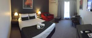 Habitación de hotel con cama grande y sofá rojo. en Hunts Hotel Liverpool, en Liverpool