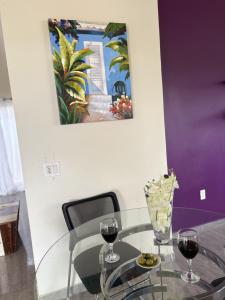 un tavolo di vetro con due bicchieri da vino e un dipinto di Charming house in Curacao a Willemstad Altre 4 foto