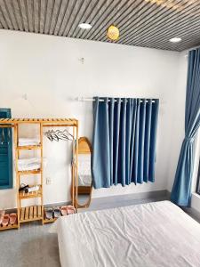 una camera con tende blu e un letto di Homestay VUVY đảo Phú Quý a Cù Lao Thu