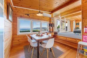a dining room with a table and white chairs at 3 Oaks on the Lake - Kinloch in Kinloch