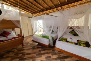 a room with two bunk beds with mosquito nets at Hotel Meraki Nuqui in Nuquí