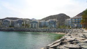a row of apartment buildings next to a body of water at Address Beach Resort Fujairah Apartment by Blue World - 1 in Fujairah