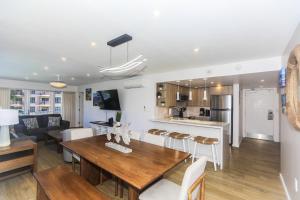 ホノルルにあるFully Furnished Ilikai Tower 525 Condo With Free Wifi, Near Best Waikiki Beaches!の木製のテーブルと椅子のあるキッチンとリビングルーム