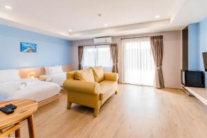 a hotel room with a bed and a couch and a tv at USABAI Riverside Boutique Hotel in Chanthaburi