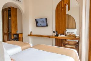 a hotel room with two beds and a mirror at Oh!Julia Hotel Komodo in Labuan Bajo
