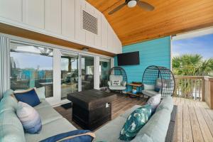 sala de estar con sofá y sillas en la terraza en Come Sail Away, en Destin