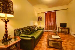 uma sala de estar com um sofá de couro verde e uma mesa em Suites on Main em Margaretville