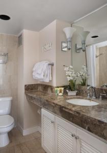 a bathroom with a sink and a toilet and a mirror at Refreshing Royal Garden Studio condo in Honolulu