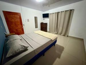 a small bedroom with a bed and a window at Hostal Sunset Town in Ahuachapán