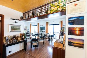 een restaurant met een eetkamer met tafels en stoelen bij Hotel Villa Carlotta in Torri del Benaco