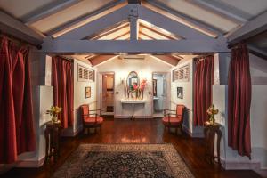an attic hallway with red chairs and a table with flowers at Dalat Palace Heritage Hotel in Da Lat