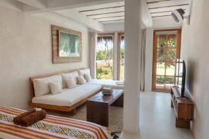 a living room with a white couch and a tv at Rote Beach House in Nembrala