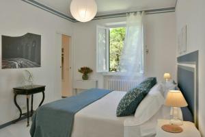 a white bedroom with a bed and a window at Seaside Villa In Marina Di Bibbona Pine Forest in Marina di Bibbona