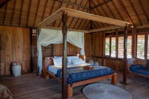 a bedroom with a canopy bed in a room at Rote Beach House in Nembrala