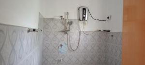a bathroom with a shower with a cell phone on the wall at New Summer Set Inn in Dambulla +92 photos