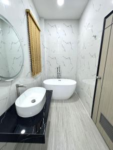 a white bathroom with a sink and a mirror at The White House Pool Villa Pattaya in Jomtien Beach