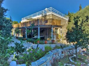 stary kamienny dom z balkonem na górze w obiekcie Eco Secluded hand built stone house in an oasis w Mastichárionie