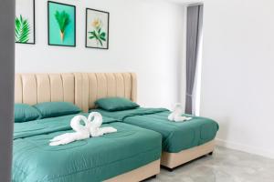 two beds with white towels on them in a bedroom at The White House Pool Villa Pattaya in Jomtien Beach +68 photos