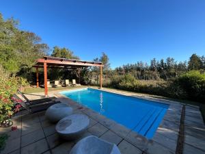 a swimming pool with a gazebo and a swimming poolvisor at Ndlovu Addo River Lodge in Kirkwood