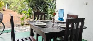 a wooden table with chairs and plates on it at New Summer Set Inn in Dambulla