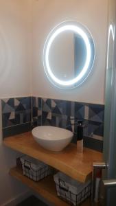 ein Badezimmer mit Waschbecken und Spiegel in der Unterkunft Resid Azur in Saint-Jean-de-Monts + 8 Fotos