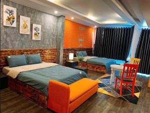 a bedroom with two beds and a table and a chair at Căn Hộ Vỹ Dạ Đà Lạt in Da Lat