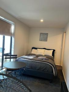 a bedroom with a bed and a table in it at Self-contained Tiny Sleepout in Hamner in Hanmer Springs