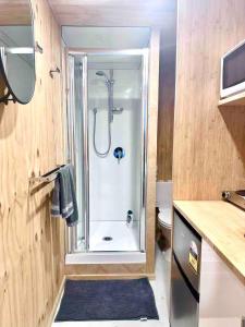 a bathroom with a shower with a glass door at Self-contained Tiny Sleepout in Hamner in Hanmer Springs